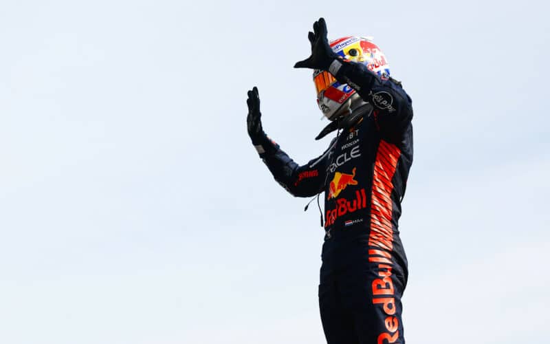 a man in a red bull racing suit waving