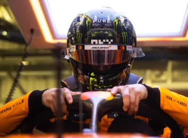 a man wearing a helmet and holding a steering wheel
